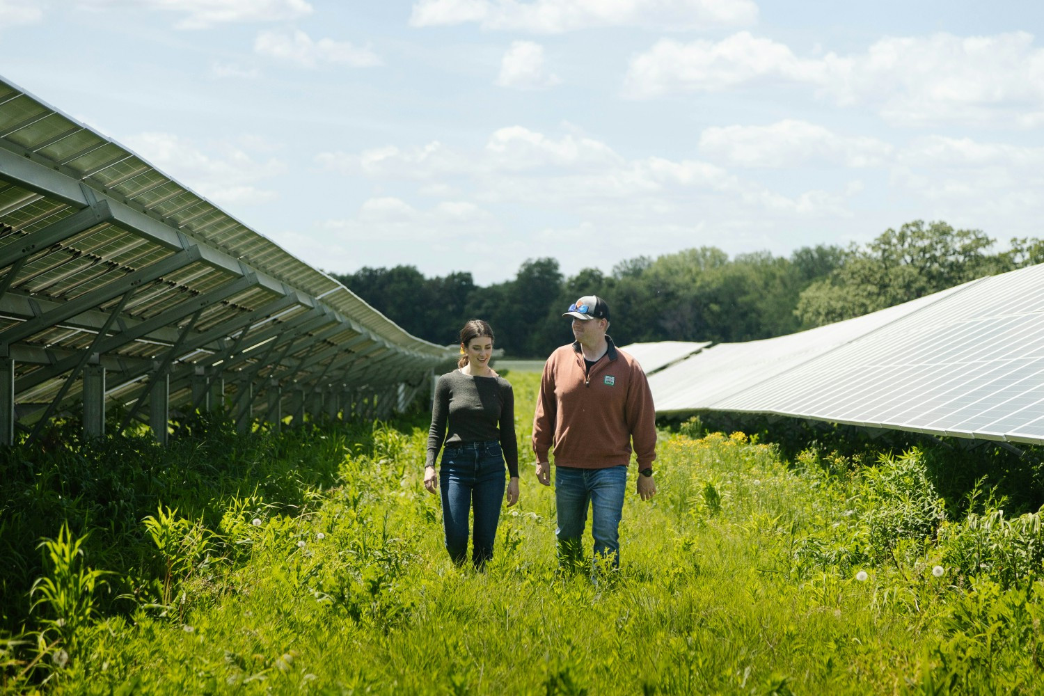 Will Jones and Lisa Caras, 7th generation family members, walk through the solar energy field located on the property.