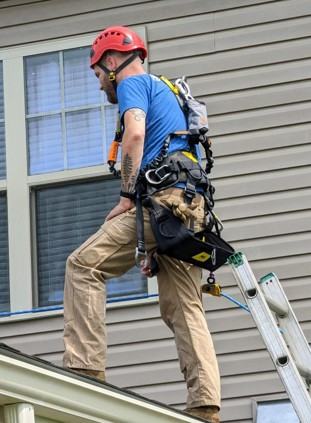 A technician on a customer's roof troubleshooting service.