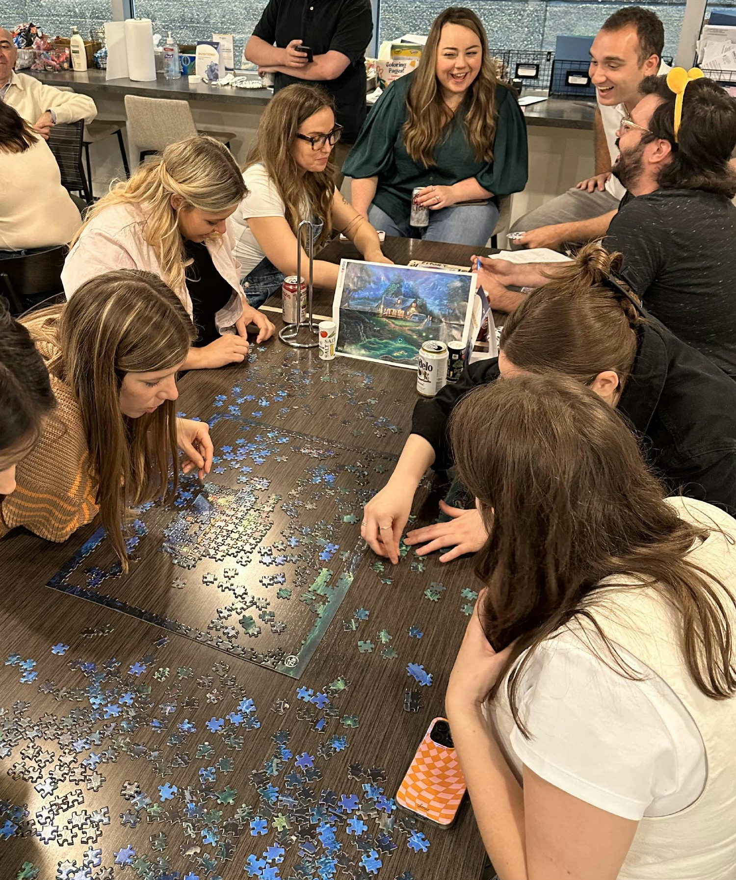 Staff building a puzzle at our annual potluck. 