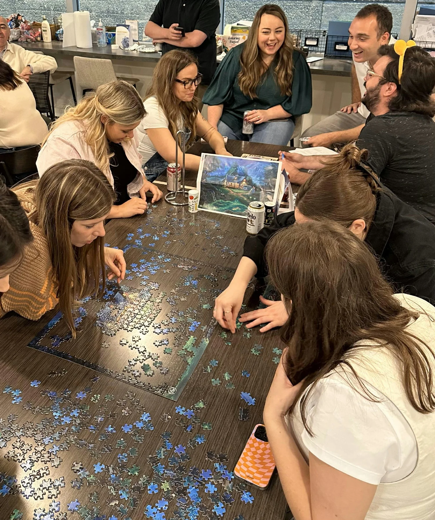 Staff building a puzzle at our annual potluck. 