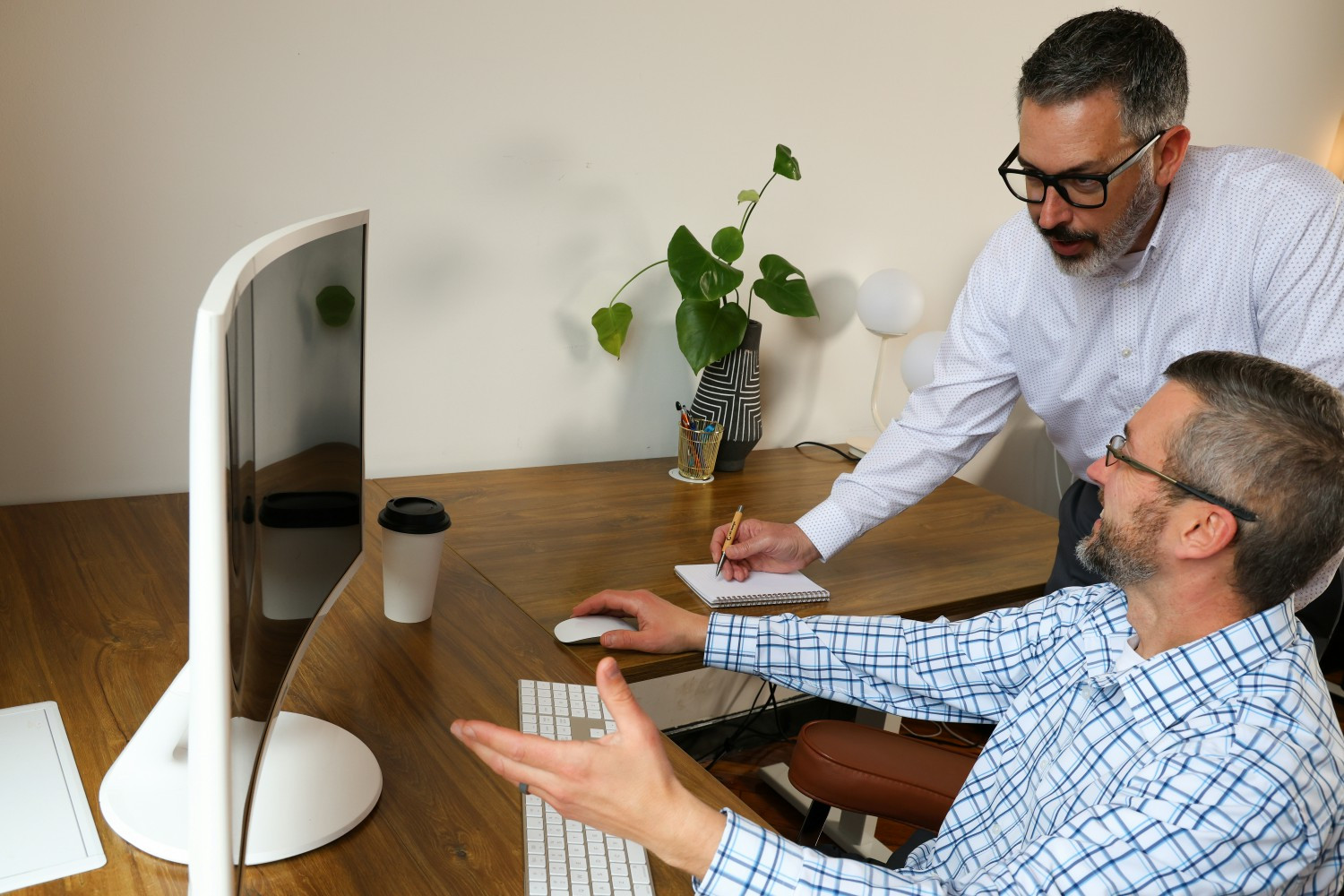 Mark and David brainstorming ideas around a workstation. 