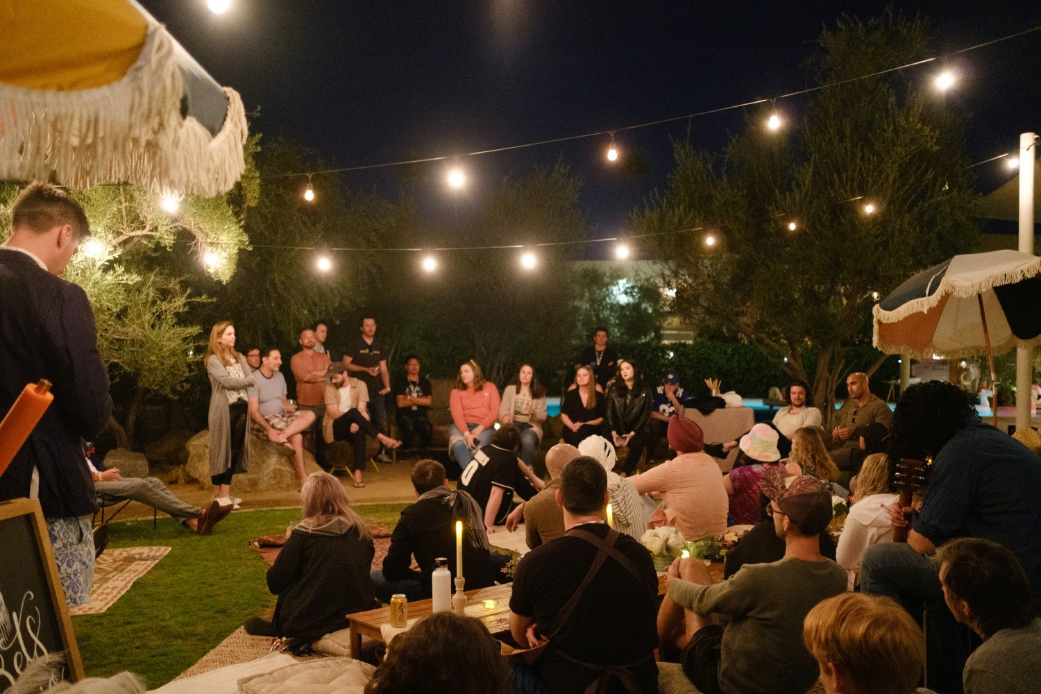 Teammates engage with the co-founders, Sam and Liam, in a casual poolside All-Hands session. 