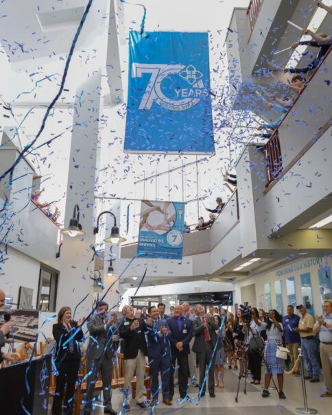 Employees and community members celebrate 70 years of service with confetti drop.