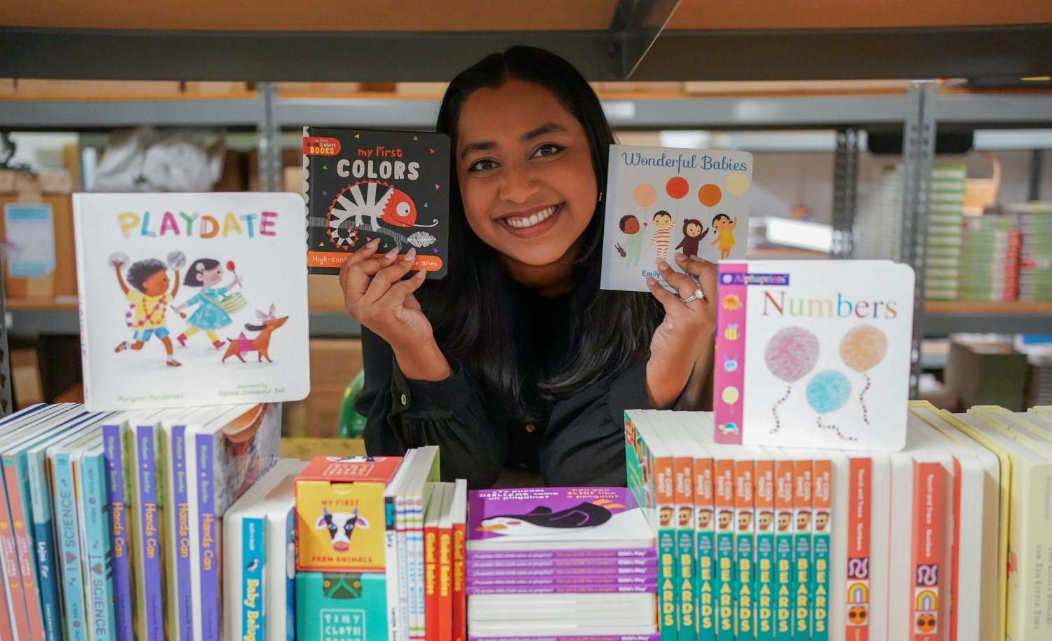 Employee with books from our early literacy programs.