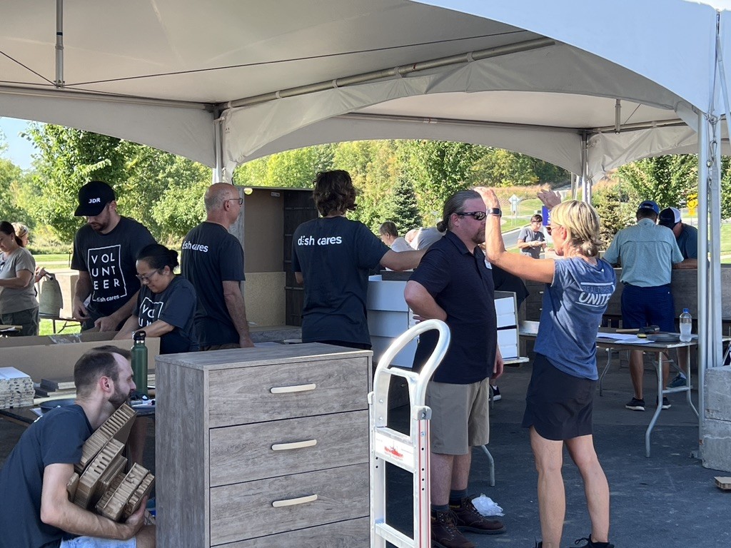 Staff pictured at a dresser build event. Hundreds of dressers are built to benefit struggling homeowners. 
