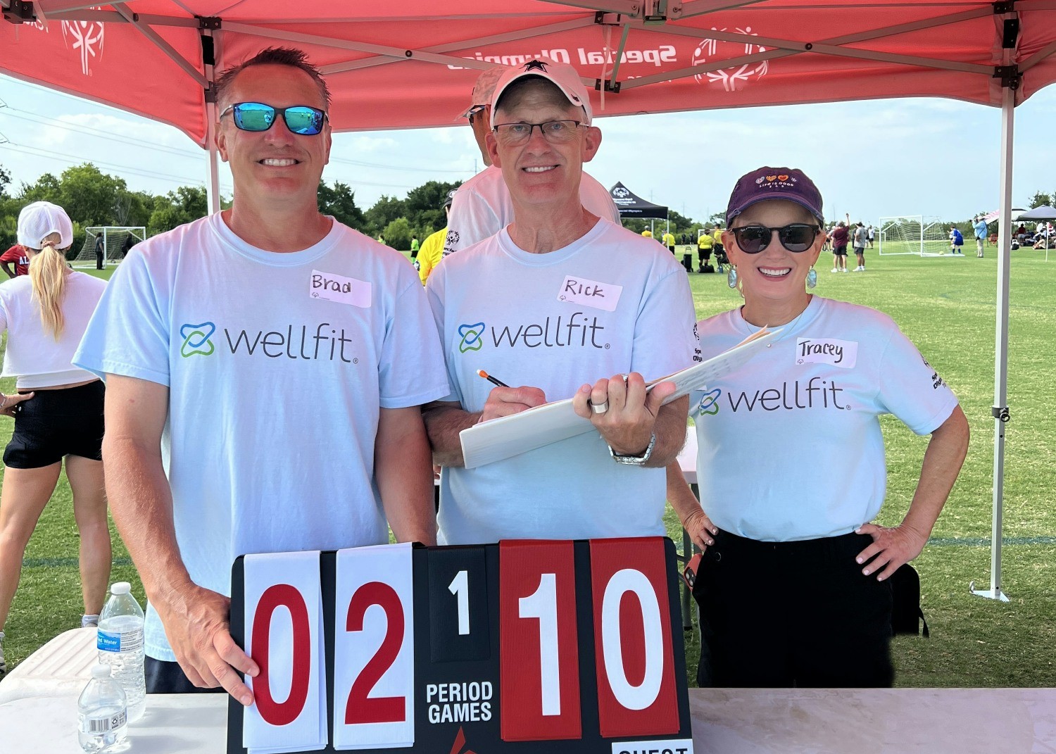 Goal! Team Wellfit hands out high fives and embraces the spirit of inclusion while volunteering at the Special Olympics.