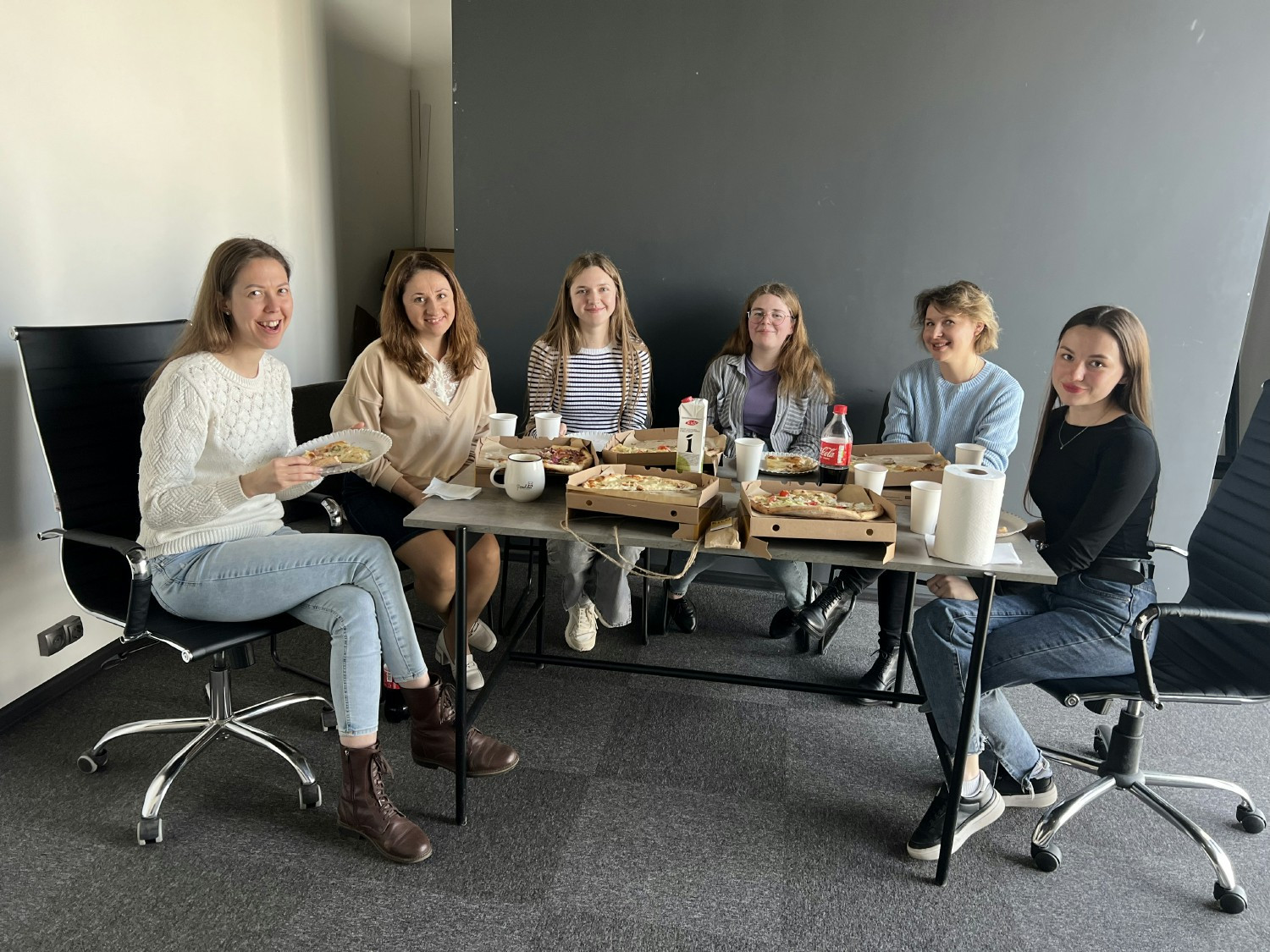 Smiling faces exchange ideas in a lively, warm office ambiance.