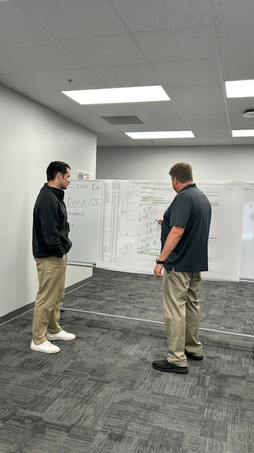 Innovation starts here; employees mapping out solutions at the whiteboard.