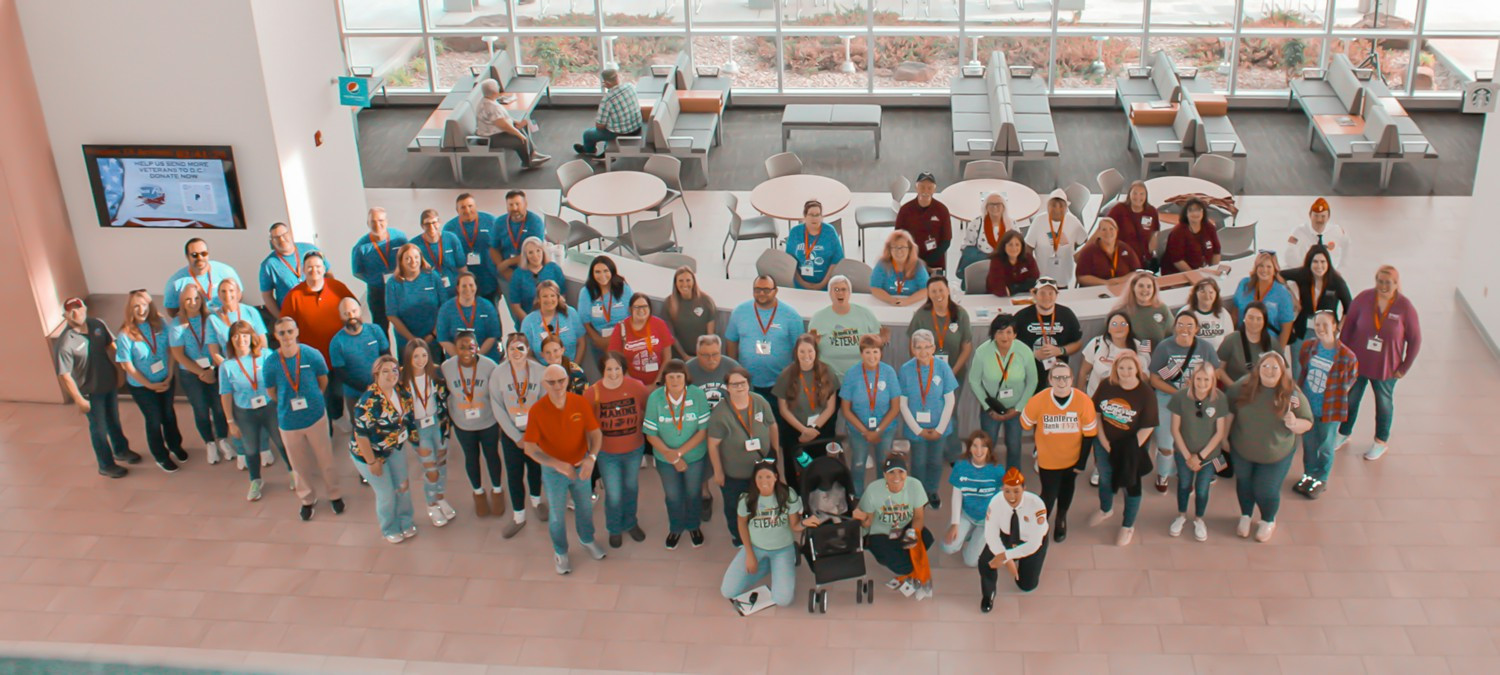 Team members gather with other volunteers to support the Veterans’ Honor Flight at Williamson County Airport.
