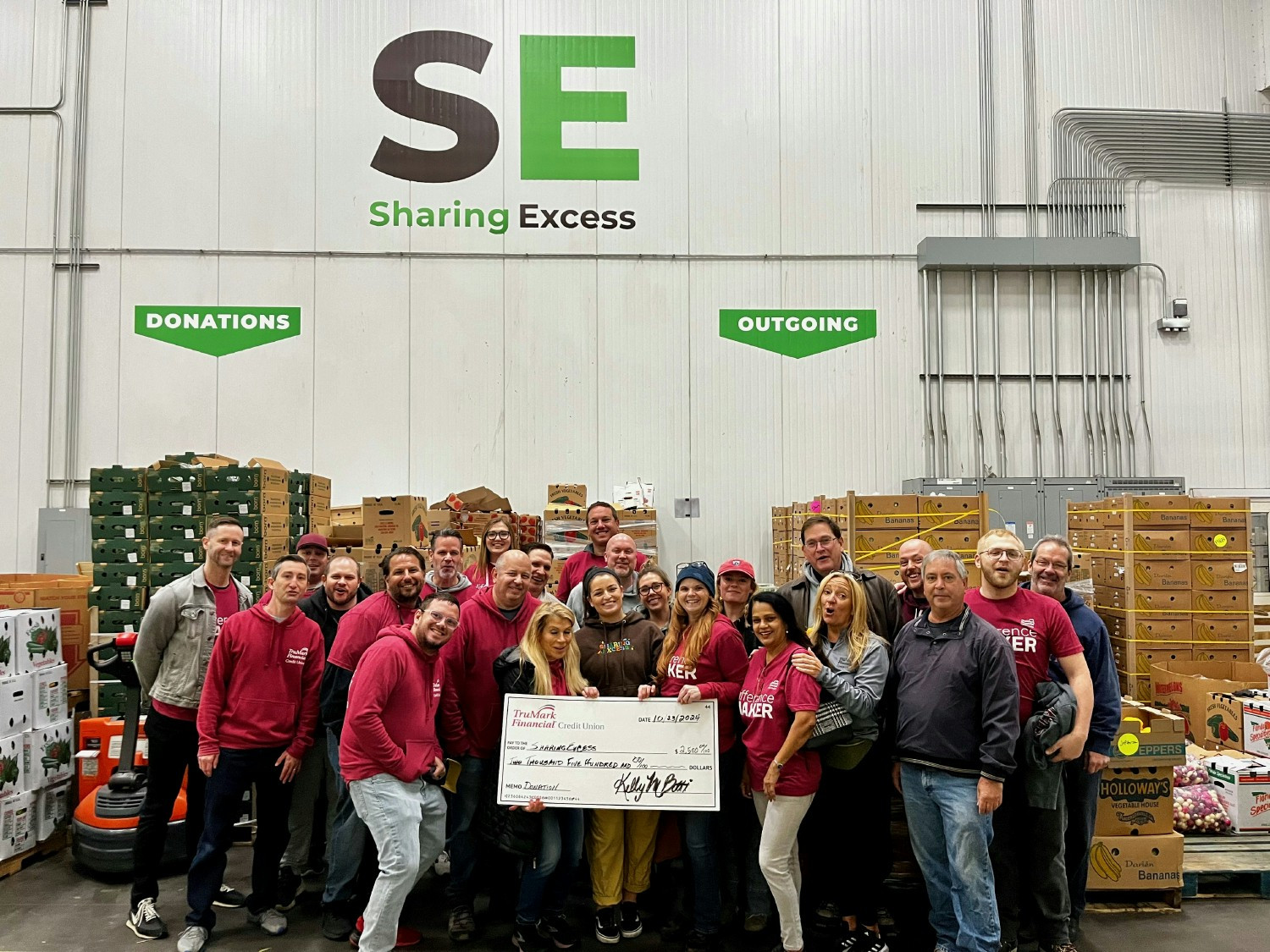 Giving back: TruMark Financial employees volunteered at Sharing Excess & presented a donation to support hunger relief.