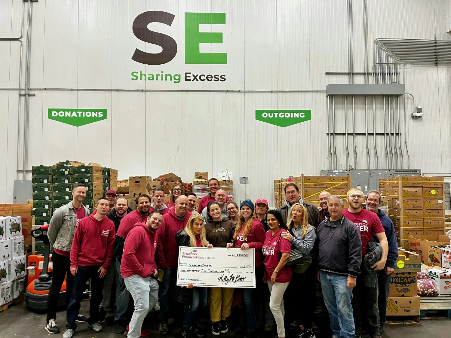 Giving back: TruMark Financial employees volunteered at Sharing Excess & presented a donation to support hunger relief.