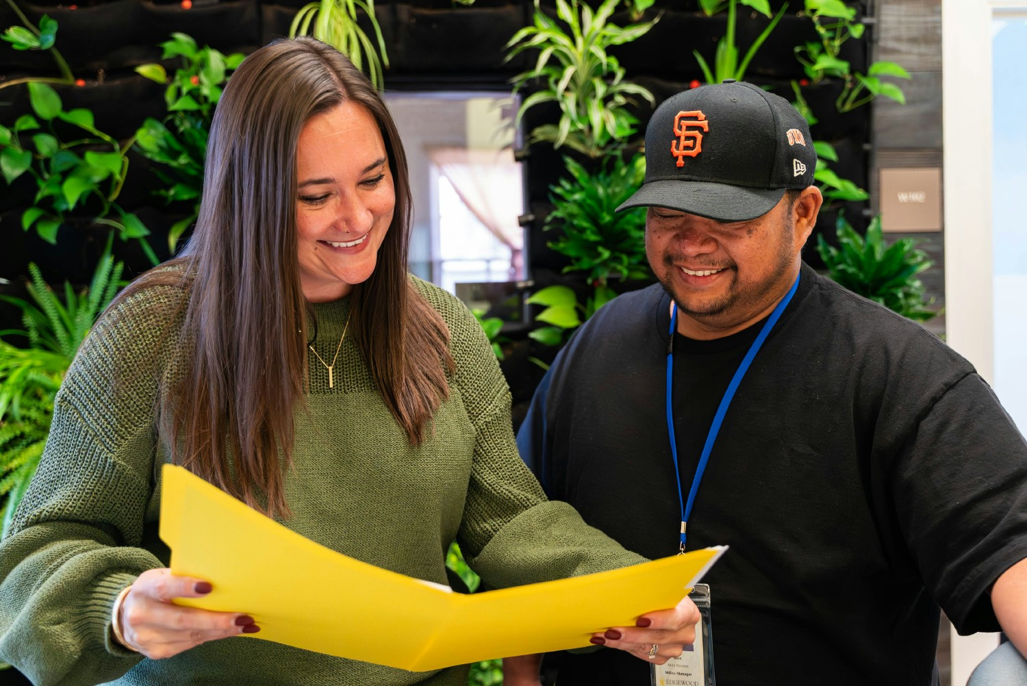 Edgewood Crisis Stabilization Unit leadership review a client report together, smiling because the client is doing well.