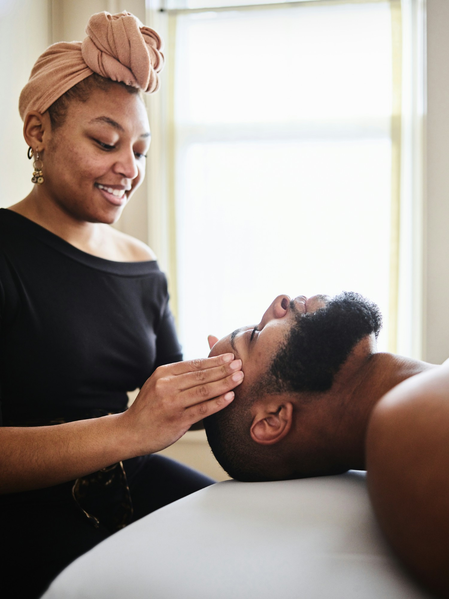 A serene moment of relaxation as Mercedes, a skilled therapist, delivers a calming facial massage.