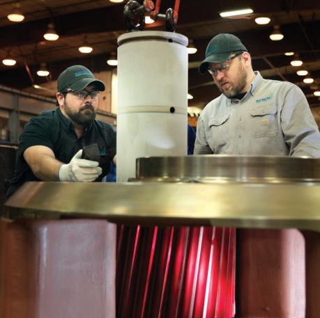 Employees collaborating to repair components.