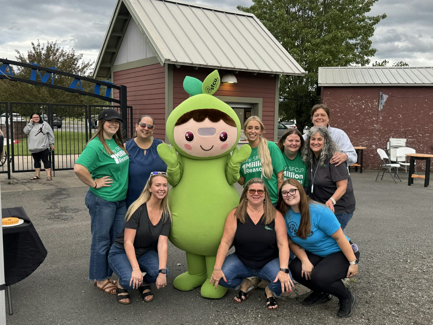 Colleagues and mascot Sprout celebrating community at an SFCU-hosted baseball night.