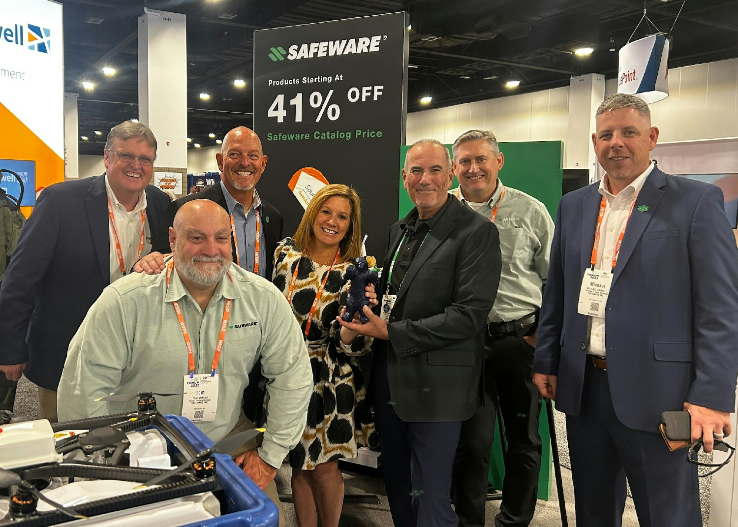 Safeware employees posing with a happy customer during a tradeshow.