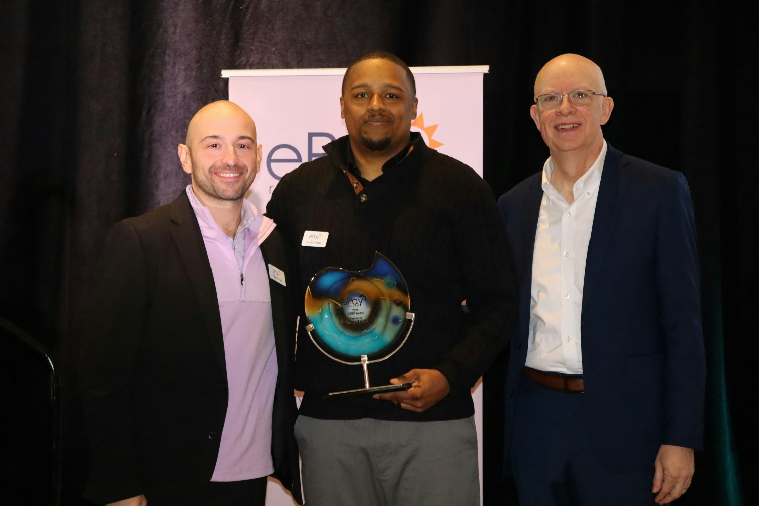 Staff member receiving our annual MERIT Award from our CFO and CEO