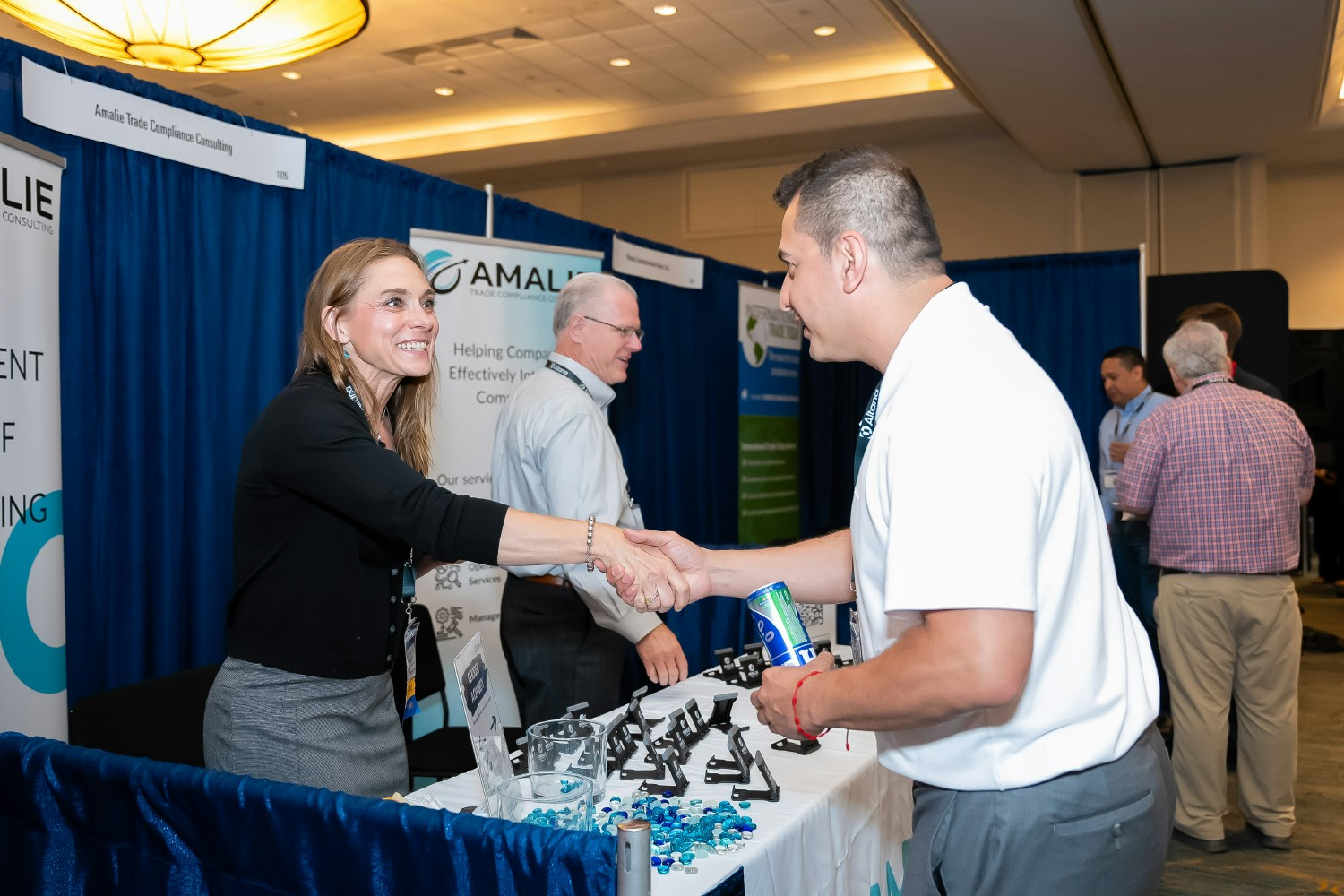 Jessi Cooper(left) makes conversation at Amalie's booth at a conference. Education & Community are core Amalie beliefs.