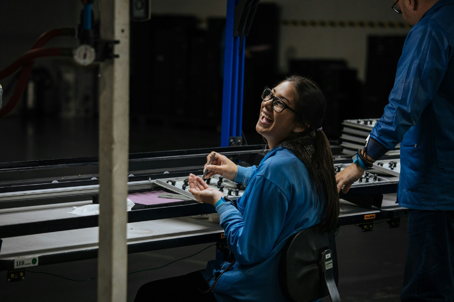 Employee in East West facility enjoying work, laughing with coworkers