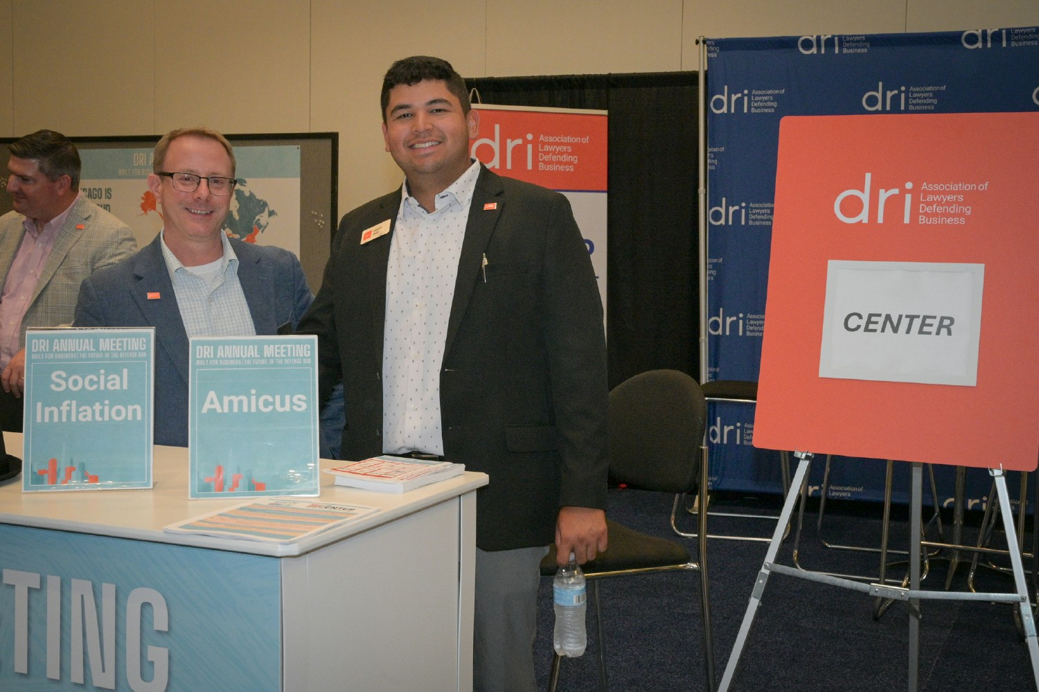 Colleagues partnering at an exhibition booth to engage with attendees and strengthen relationships within our community