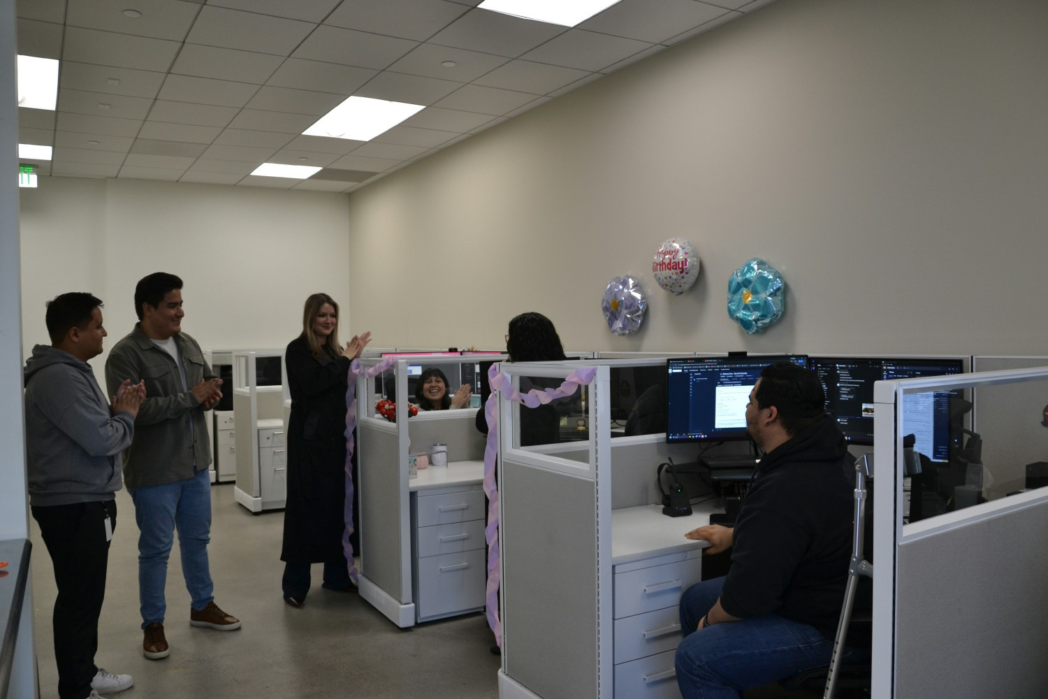 Surprising a colleague with balloons and cupcakes, reflecting genuine appreciation and everyday joy at our workplace.