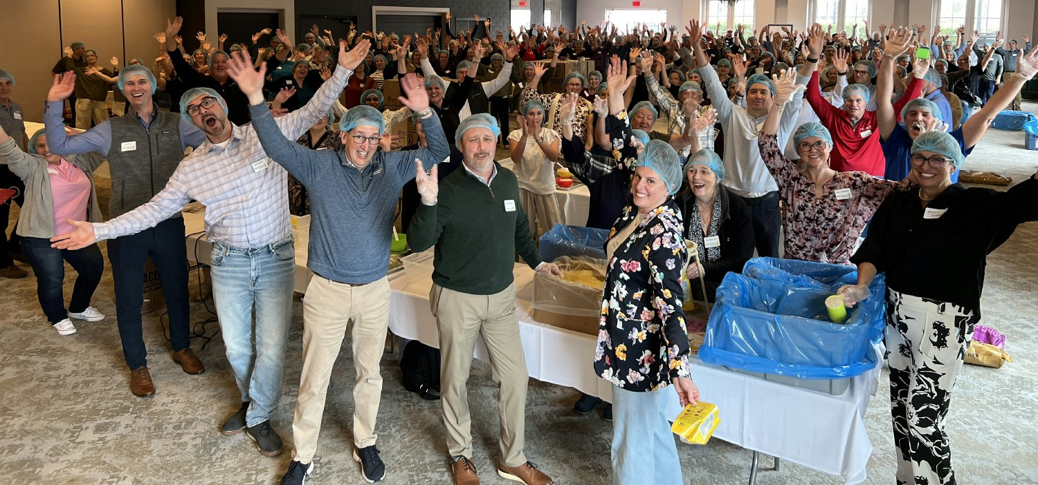 Indiana Farmers Insurance associates celebrate after packing thousands of meals as part of the Million Meal Movement.