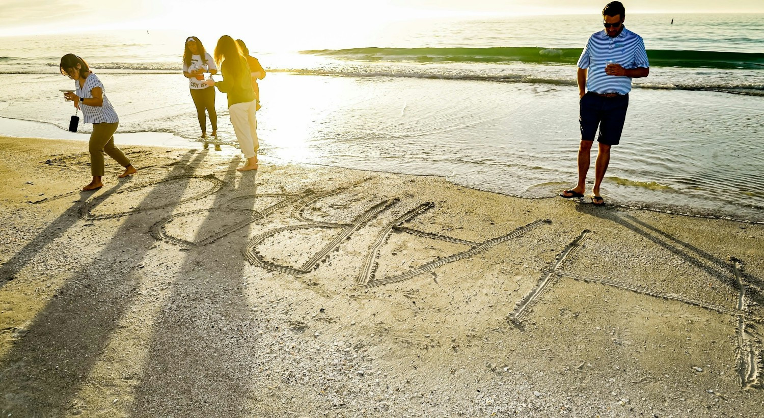 Company name drawn in the sand during company wide offsite in Florida. January 2026