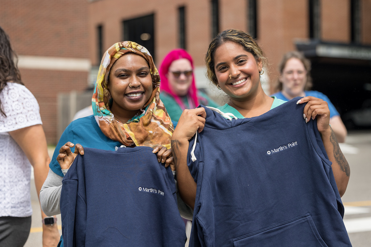 Two happy employees show off their new swag as they wait for our annual Ice Cream Day treat.