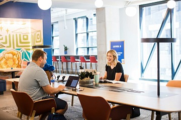 Atlassian's peer recognition program  is depicted with two coworkers having a conversation.