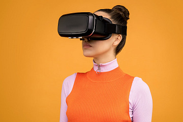 employee wearing VR headset in front of an orange background