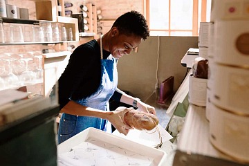 A young worker packages a loaf of bread